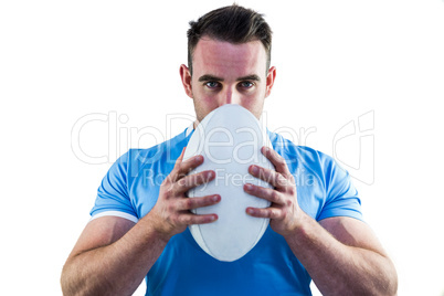 Rugby player looking at camera with ball