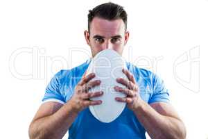 Rugby player looking at camera with ball