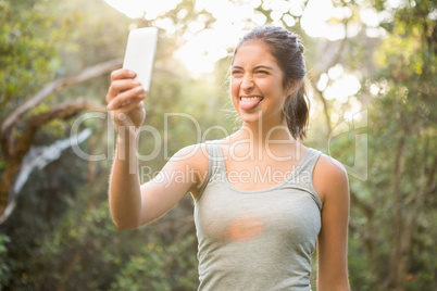Pretty atlethic brunette taking selfie with outstretched tongue