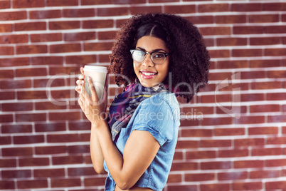 Smiling attractive hipster holding take-away cup
