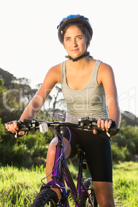 Focused athletic brunette sitting on mountain bike