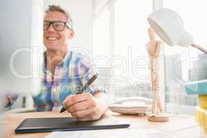 Smiling casual designer using computer and digitizer