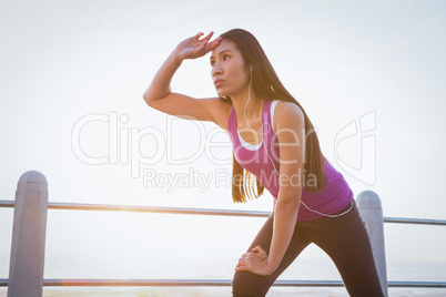 Sweating fit woman resting at promenade