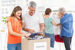 Smiling casual business people sorting donations