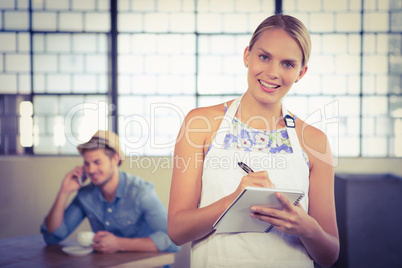 Portrait of a beautiful waitress taking an order