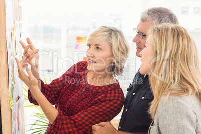 Attentive business team looking at notes on the wall