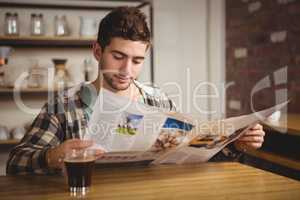 Hipster having coffee and reading newspaper