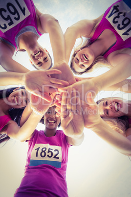 Five smiling runners supporting breast cancer marathon