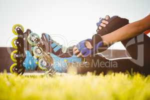 Woman wearing inline skates sitting in grass