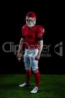 Portrait of american football player holding football