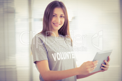 Smiling brunette volunteer with tablet