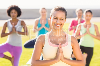 Smiling sporty brunette doing yoga in yoga class