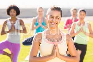 Smiling sporty brunette doing yoga in yoga class