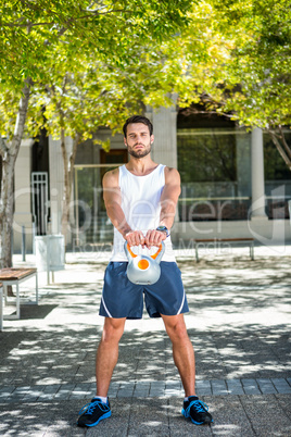 Handsome athlete outfit with a kettlebell