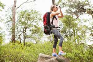 Blonde hiker looking through binoculars