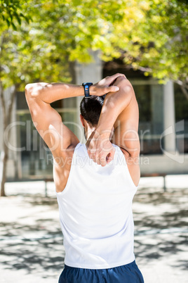 Rear view of athlete stretching his arm