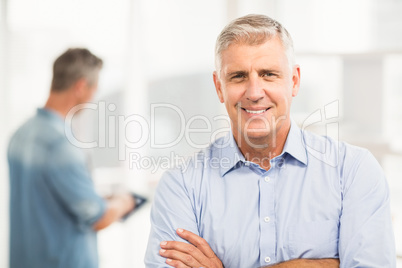 Smiling businessman with arms folded