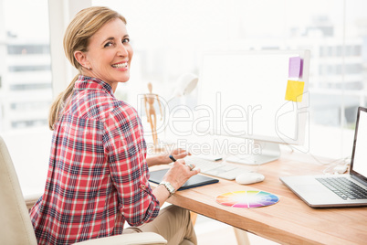 Smiling casual designer using computer and digitizer