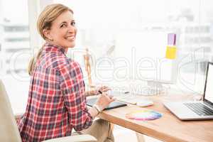 Smiling casual designer using computer and digitizer