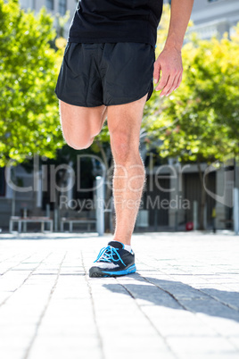 Athletic man doing a leg stretching