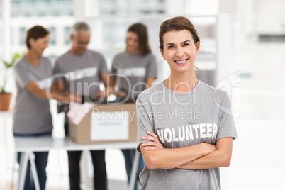 Smiling female volunteer with arms crossed