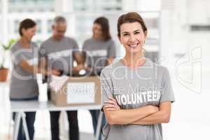 Smiling female volunteer with arms crossed