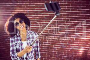 Attractive hipster taking selfies with selfiestick