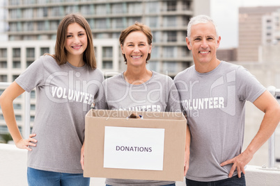 Smiling volunteers holding donation box