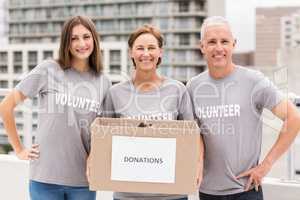 Smiling volunteers holding donation box