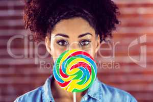 Portrait of a beautiful woman holding a giant lollipop