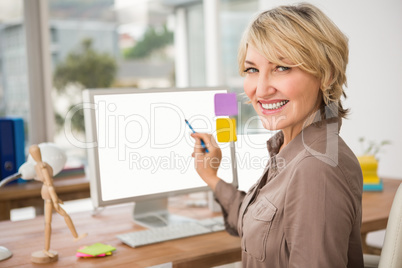 Smiling casual designer pointing blank computer screen