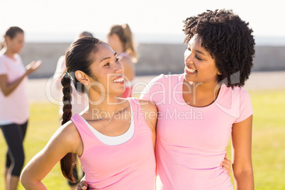 Smiling young women wearing pink for breast cancer