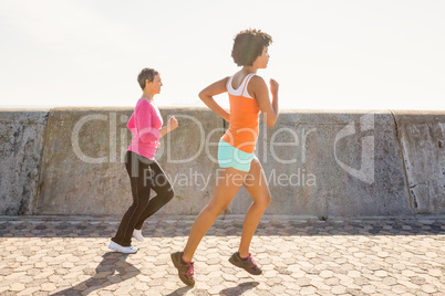 Two sporty women jogging together