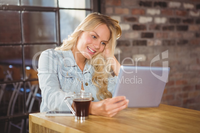 Smiling blonde holding tablet computer