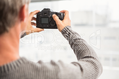 Rear view of man taking pictures with camera