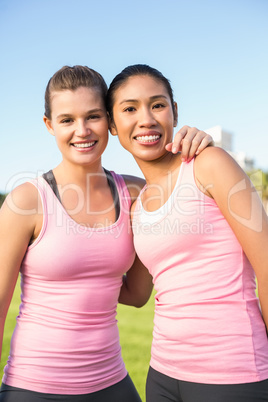 Two smiling women wearing pink for breast cancer