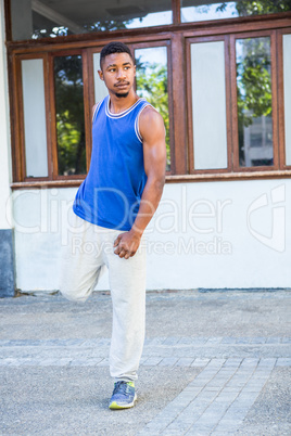 An handsome athlete stretching his leg