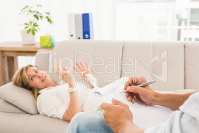 Therapist listening to female patient and taking notes