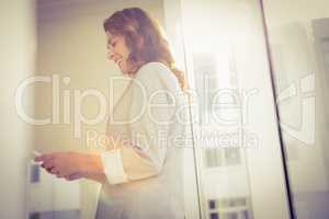 Smiling casual businesswoman using smartphone