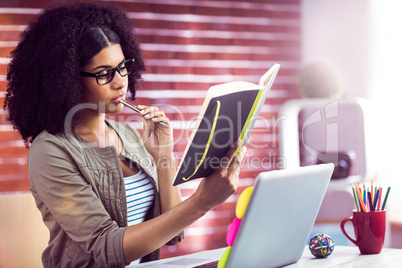 Casual businesswoman looking in her diary