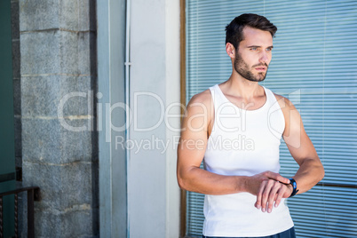 Handsome athlete checking heart rate watch