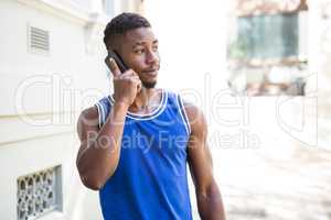 An happy handsome athlete calling