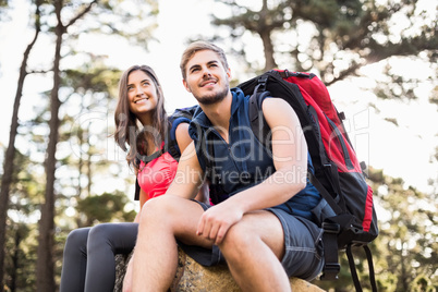 Young happy joggers sitting on rock and looking away