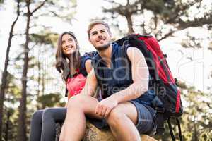 Young happy joggers sitting on rock and looking away
