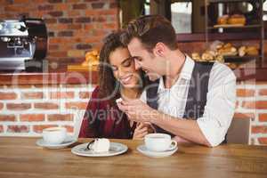 Young happy couple feeding each other with cake