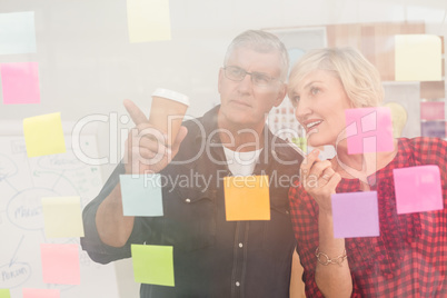 Business team pointing post its on the wall