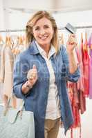 Smiling woman going shopping and showing credit card