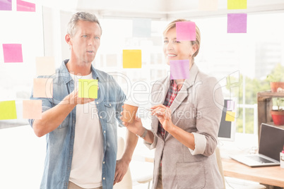 Casual business colleagues working with sticky notes Casual business colleagues working with sticky notes
