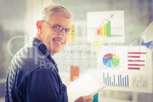 Smiling businessman holding a digital tablet