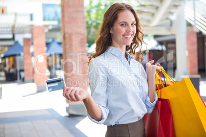 Pretty woman shopping at the mall with card